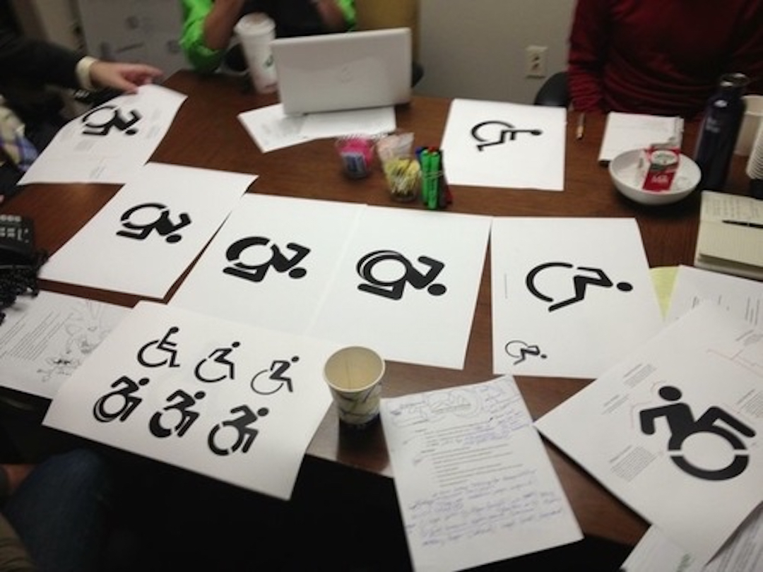 We worked with our extended team, including self-advocates with disabilities and allies, to iterate through various possibilities, shown strewn over a table on paper here, for the final icon.